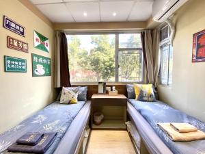 two beds in a room with a window at AMU Dreamhouse 阿木旅舍 in Hong Kong