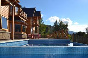 a house with a swimming pool in front of a house at Sieteflores Hosteria De Montaña in San Martín de los Andes
