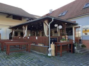 een restaurant met houten tafels voor een gebouw bij Penzion pivovarská restaurace Moravia in Brno