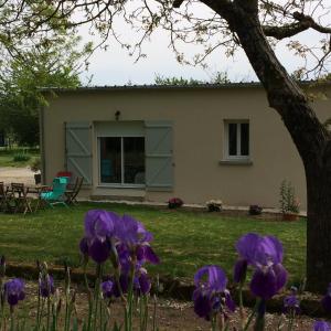 una casa con flores púrpuras delante de ella en la Sainterie, en Savonnières