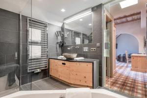 a bath room with a tub, sink and mirror at Sport- und Genusshotel Silvretta in Ischgl