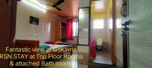 a bathroom with a room with a bed and a toilet at Gokarna RSN STAY in Top Floor for the Young & Energetic people of the Universe in Gokarna