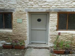 una puerta de un edificio de piedra con macetas delante en The Merchant's House, en Penryn