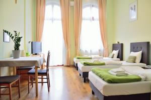 a room with four beds and a table and a desk at WenderEDU Business Center in Wrocław