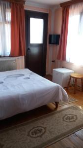 a bedroom with a bed and a window and a door at Guest House Bolyarka in Koprivshtitsa