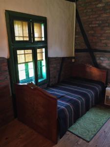 a bed in a room with two windows at Etno Kuća - Rakić in Svrljig +25 photos