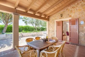 d'une terrasse avec une table et des chaises en bois. dans l'établissement Sa Cova Dor, à Santa Margalida