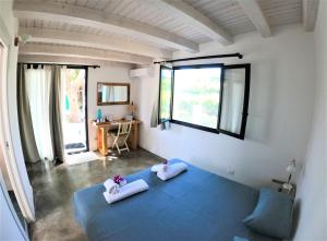 a bedroom with a blue bed with two pillows on it at MAYANA SICILY - The suites in Santa Maria Del Focallo