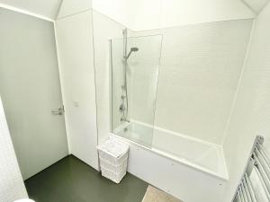 a white bathroom with a shower and a tub at Large Townhouse 5 Beds with Two Parking Spaces - Manchester City Centre in Manchester