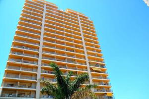 a tall building with a palm tree in front of it at ROCASOL - Beach in Calpe