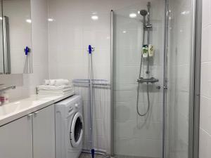 uma casa de banho com um chuveiro e uma máquina de lavar roupa em Time Apartments Ylistönmäki em Jyväskylä