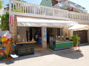 un puesto de comida con un balcón encima en Apartmani Danica, en Gradac