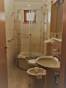 y baño con aseo, lavabo y ducha. en Hotel vila veneto, en Timisoara