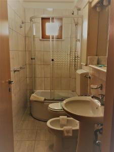 a bathroom with a toilet and a sink and a shower at Hotel vila veneto in Timişoara