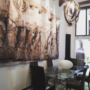 a dining room with a painting on the wall at Sinagoga in Peñaranda de Duero