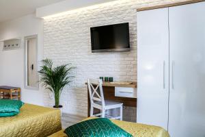 sypialnia z telewizorem na murze w obiekcie Apartament Podlaskidron w mieście Białystok