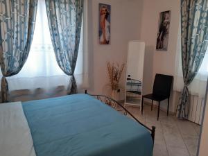 een slaapkamer met een bed, een stoel en een raam bij Parma Holiday 2020+21 in Parma