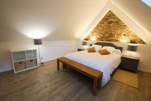 a bedroom with a large bed and a stone wall at Domaine des Fougères in Guimaëc