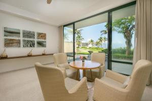 a living room with a table and chairs and a large window at Abogo Resort Villas Beachview Da Nang in Danang