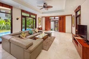 a living room with a couch and a tv at Abogo Resort Villas Luxury Da Nang in Da Nang