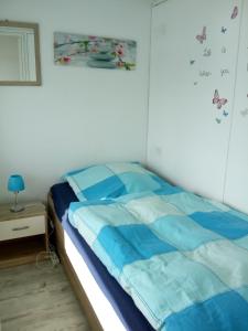 ジールクスドルフにあるOstseeparadies Sierksdorf Panoramicのベッドルーム1室(青と白のシーツが備わるベッド1台付)