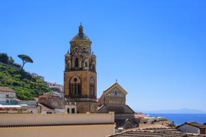 a tall tower with a clock on the top of a city at Amalfi Suite Boutique Hotel in Amalfi