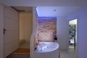 a bath tub in a room with a brick wall at Amalfi Suite Boutique Hotel in Amalfi