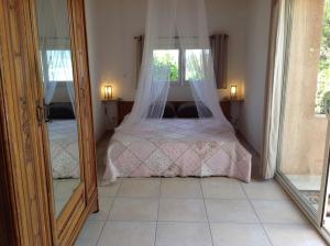 a bedroom with a bed with a window and a mirror at La Coccinelle in Île du Levant