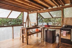 a kitchen with windows and a table and a stove at CocoVivo in Bocas Town