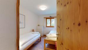 um pequeno quarto com uma cama e um espelho em Abitaziun Murinella - Pontresina em Pontresina