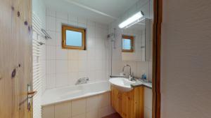 um banheiro com banheira, pia e banheira em Abitaziun Murinella - Pontresina em Pontresina mais 24 fotografias