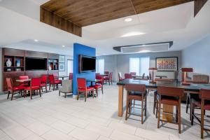a dining room with tables and chairs and a flat screen tv at Holiday Inn Express & Suites Tell City, an IHG Hotel in Tell City