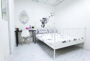 a white bedroom with a bed and a desk at G Traveler Accommodation Homes 居旅舍 in Kota Damansara
