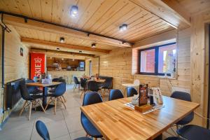 a restaurant with wooden walls and tables and chairs at Pensjonat & Restauracja Lustrzany Zakątek in Szczyrk