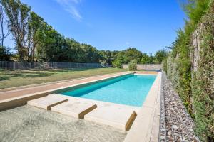 a swimming pool with two chaise lounges next to a fence at Résidence Pierre & Vacances Le Fort de la Rade in Île dʼAix