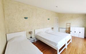 Duas camas brancas num quarto com pisos em madeira em Best Guest Porto Hostel no Porto