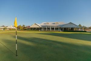 a golf course with a yellow flag in front of a building at Big River Golf & Country Club in Berri
