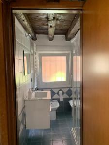 a bathroom with a toilet and a sink and a window at Calle Zen Home in Venice