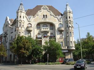 ein Gebäude mit einem davor geparkt in der Unterkunft Gróf palace Apartman in Szeged