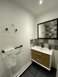 a bathroom with a sink and a mirror at La Propriete de Bacchus in Saumur