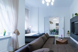 ein Wohnzimmer mit einem Sofa und einem Bett in der Unterkunft Gróf palace Apartman in Szeged
