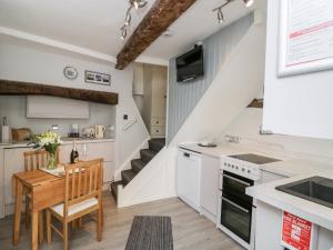eine Küche und ein Esszimmer mit weißen Schränken und einem Tisch in der Unterkunft Cobblers Cottage in Worcester