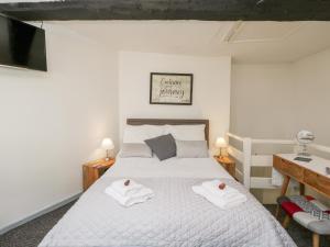 ein Schlafzimmer mit einem Bett mit Handtüchern darauf in der Unterkunft Cobblers Cottage in Worcester
