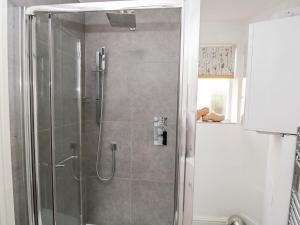 a shower with a glass door in a bathroom at Cobblers Cottage in Worcester