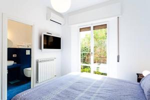ein weißes Schlafzimmer mit einem Bett und einem Fenster in der Unterkunft Casa Milena in Sorrent