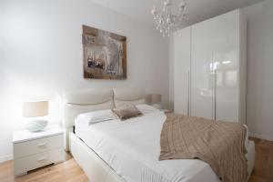 ヴェネツィアにあるSan Marco Prestige with Terrace by Wonderful Italyの白いベッドルーム(シャンデリア付)の白いベッド1台
