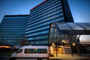 un furgone bianco parcheggiato di fronte a un edificio di Crowne Plaza Milan Linate, an IHG Hotel a San Donato Milanese