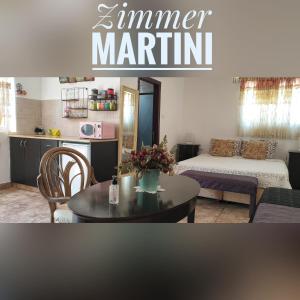 a living room with a table and a bedroom at Martini Dead Sea in Neve Zohar