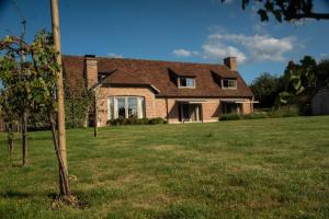 ein Haus mit einem Rasenplatz davor in der Unterkunft B&B Sett in Horebeke