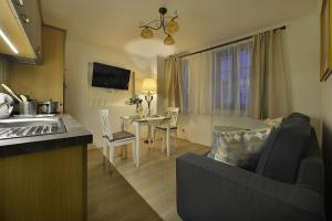 a kitchen and living room with a couch and a table at Nobles Apartments in Prague
